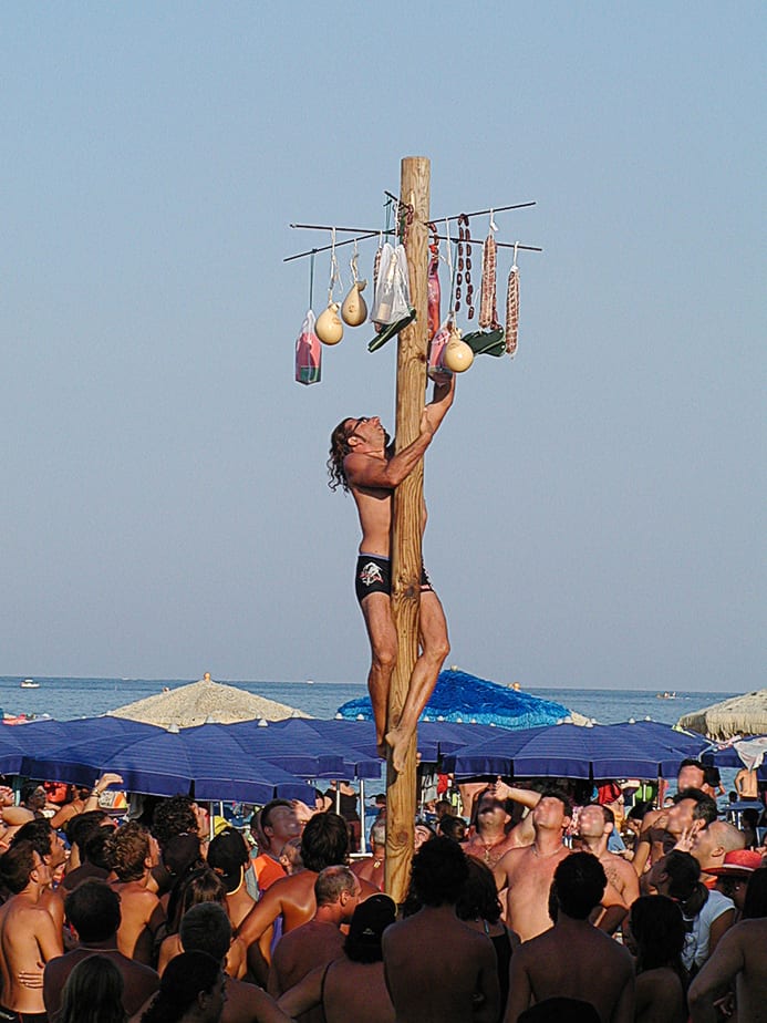 A man climbing a greasy pole