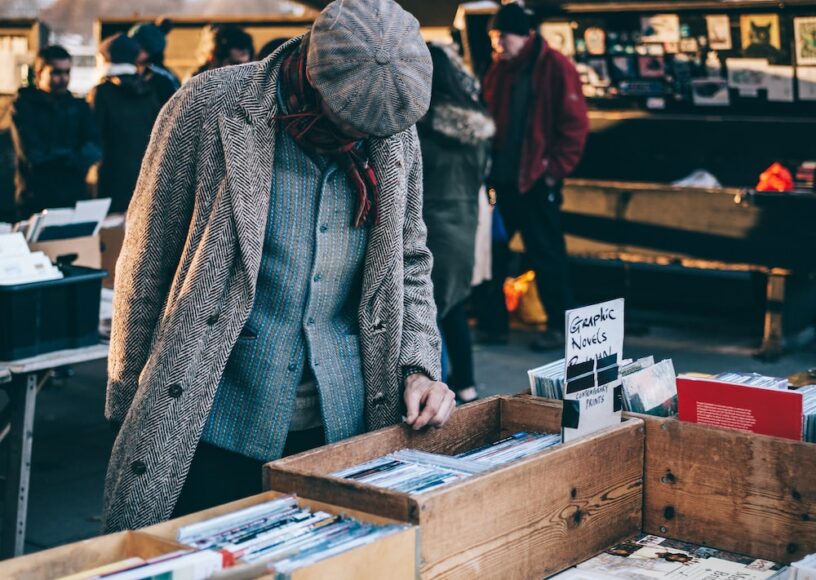 A man veiwing the books in a flea market - Unsplash
