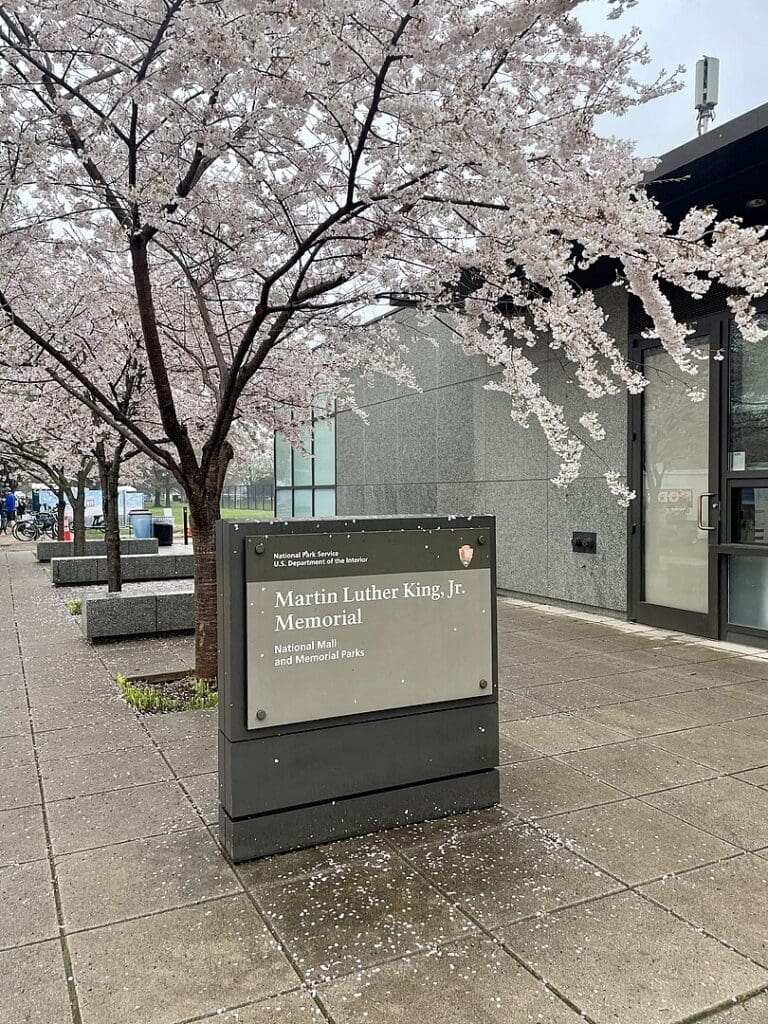 Martin Luther King, Jr.'s Memorial National Park Service sign next to the gift shop during cherry blossom season.