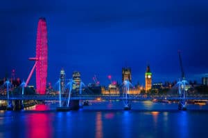 London panorama of Millennium wheel, Big Ben with the Houses of Parliament and Hungerford and Golden Jubilee bridges over River Thames at dusk